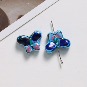 Gros plan de perles papillon en céramique peintes à la main pour bijoux DIY