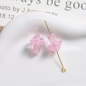 Close-up of pink translucent glass mushroom beads with spiral patterns for DIY jewelry