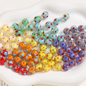 Close-up of 10mm colorful polka dot glass beads in a white tray for DIY jewelry