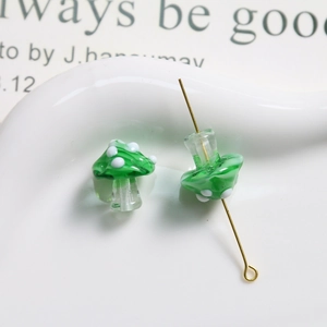 Macro shot of green polka dot glass mushroom beads with central drill holes for DIY jewelry