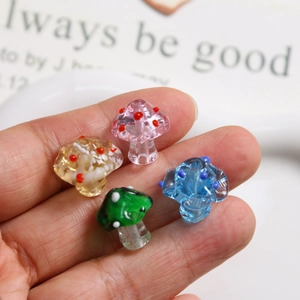 Close-up of translucent glass mushroom beads with colorful dots for DIY jewelry