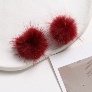 Detailed view of two 3.5cm deep red mink fur balls for DIY jewelry and hair accessories
