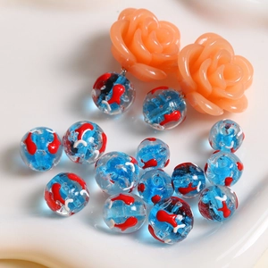 Gros plan de perles en verre océan 12mm avec motifs de poissons et clous en résine florale