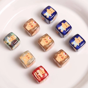 Detailed view of colorful acrylic cube beads with cute bear prints on white tray