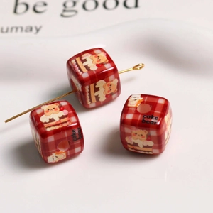 Macro shot of red plaid acrylic cube beads featuring cute bear and cake cartoon prints
