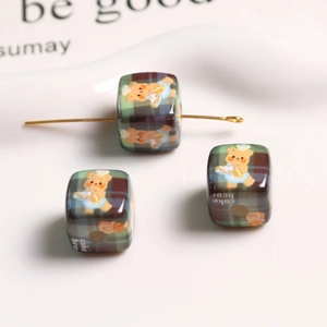Macro shot of retro plaid acrylic beads featuring cute chef bear design for DIY jewelry