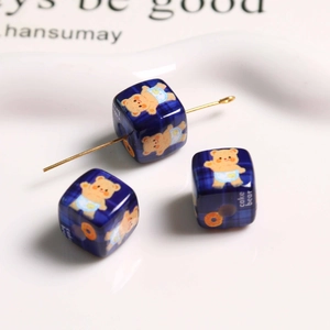 Macro detail of square blue plaid beads with bear and cake patterns for DIY jewelry