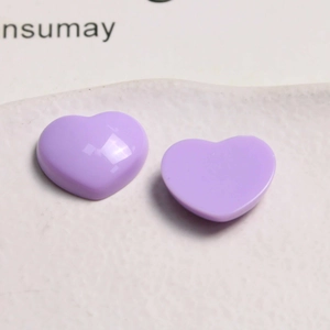 Detail view of two glossy purple heart-shaped acrylic charms for DIY jewelry accessories