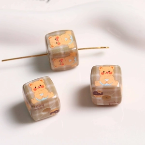 Macro shot of plaid bear and cupcake print acrylic square beads for DIY jewelry making
