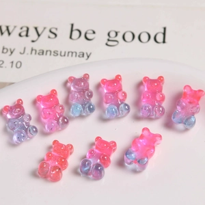 Close-up of nine translucent glitter resin bear charms for DIY jewelry and hair accessories