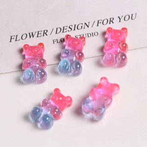 Detailed view of translucent resin bear charms with pink-blue gradient and glitter sparkles