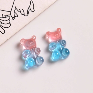 Macro detail of glitter resin bear pendants with pink and blue gradient for DIY jewelry