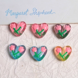 Dettaglio di perle a forma di cuore con motivi di tulipani per gioielli fai-da-te e catene