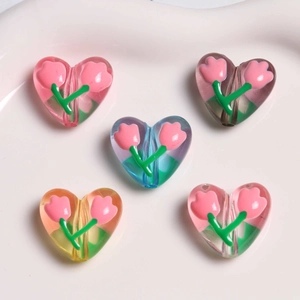 Dettaglio macro di perle in acrilico a forma di cuore con motivi floreali di tulipani