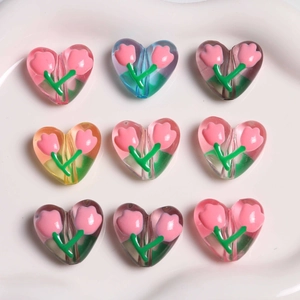 Dettaglio macro di perline acriliche a forma di cuore con tulipani 3D per gioielli fai da te