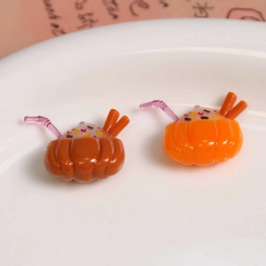 Détail macro d'accessoires en résine citrouille avec pailles roses pour bricolage DIY