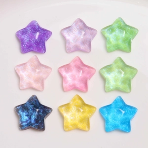 Macro detail of nine glitter resin star charms in assorted pastel candy colors for DIY crafts