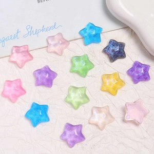 Macro shot of colorful star resin charms with glitter for DIY crafts on white background