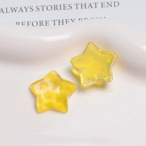 Macro view of yellow translucent resin star charms with glitter for DIY jewelry
