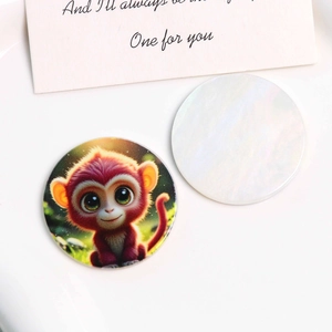Détail de l'accessoire en acrylique rond avec imprimé singe coloré et dos blanc uni