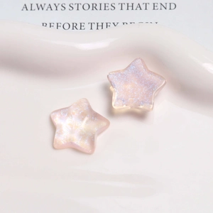 Macro detail of glittery star-shaped resin charms with aurora iridescent finish