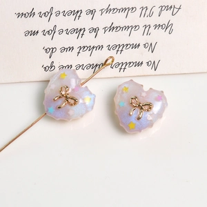 Detail of lavender heart resin charm with gold bow and glitter for DIY jewelry making