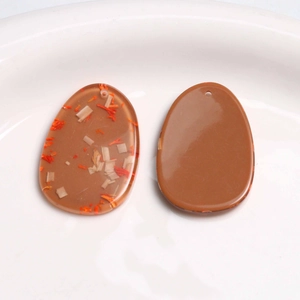 Macro view of oval resin pendants with embedded wood chips for DIY jewelry making