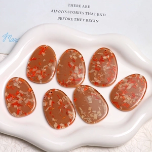 Detailed close-up of amber resin oval pendants with wood chips and dried flowers