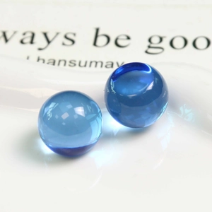 Macro de deux perles en résine bleue montrant une finition lisse et un éclat brillant