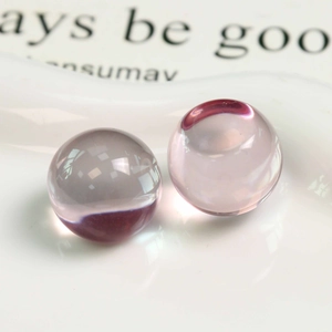 Vue macro de deux perles en résine rose translucide pour la création de bijoux DIY