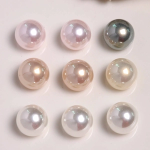 Macro shot of 9 colorful glossy round pearls in pink, grey, and white for DIY jewelry crafts