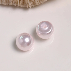 Macro detail of high-luster pale pink round pearls with drill holes for DIY jewelry