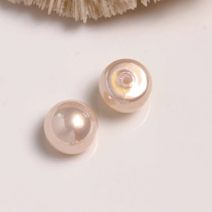 Macro detail of champagne pink pearl beads for DIY earrings with smooth pearlescent finish