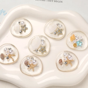Close-up of resin seashell charms with pearls and starfish for DIY ocean themed crafts