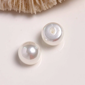 Detail of high-gloss white half-round pearl cabochons for DIY earring and shoe accessories