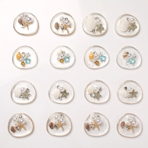 Macro detail of 16pcs ocean-themed resin charms with shells and pearls for DIY crafts