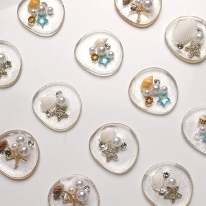 Detailed view of DIY resin charms with shells, pearls and starfish for phone case decor