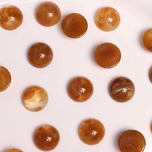 Détail macro de cabochons en résine ambre 18mm avec texture marbrée pour la création de bijoux