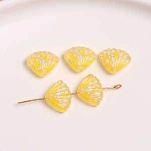 Macro detail van gele hars schelp kralen met glitter en voorgeboorde gaten voor DIY sieraden