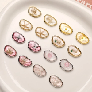 Macro detail of 15 DIY jewelry charms featuring starfish, dried flowers, and pearls