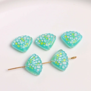 Detail van blauwe schelphars bedeltjes met gekleurde stippen voor DIY-sieraden maken