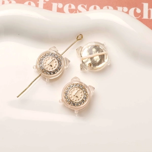 Dettaglio macro di perline mini sveglia oro champagne con strass scintillanti per DIY