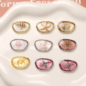 Detailed macro view of 9 unique DIY charms featuring resin shells and dry flowers