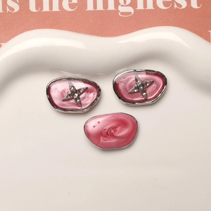 Macro detail of pink resin charms with silver alloy edges and crystal star accents