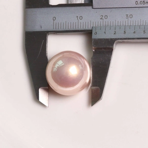 Macro shot showing measurement of a 12.5mm pink-purple round pearl with high luster