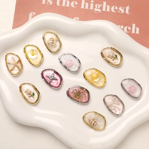 Macro detail of mixed alloy charms with dried flowers and starfish for DIY jewelry