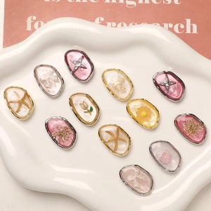 Detailed assortment of oval resin floral charms with sea star and metal frame