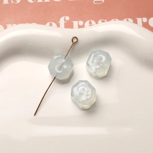 Primer plano de cuentas de resina azul claro brillante con luna y estrellas para joyería DIY