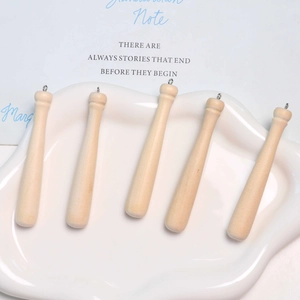 Detalle de mini colgantes de madera con forma de bate de béisbol en bandeja cerámica