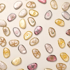Detailed macro view of DIY oval resin pendants with embedded starfish and dried flowers